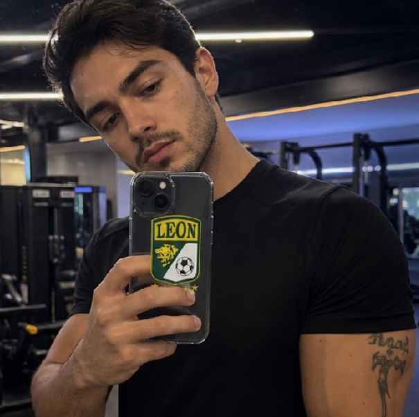 Man holding a phone with a 'Leon' logo in a gym setting