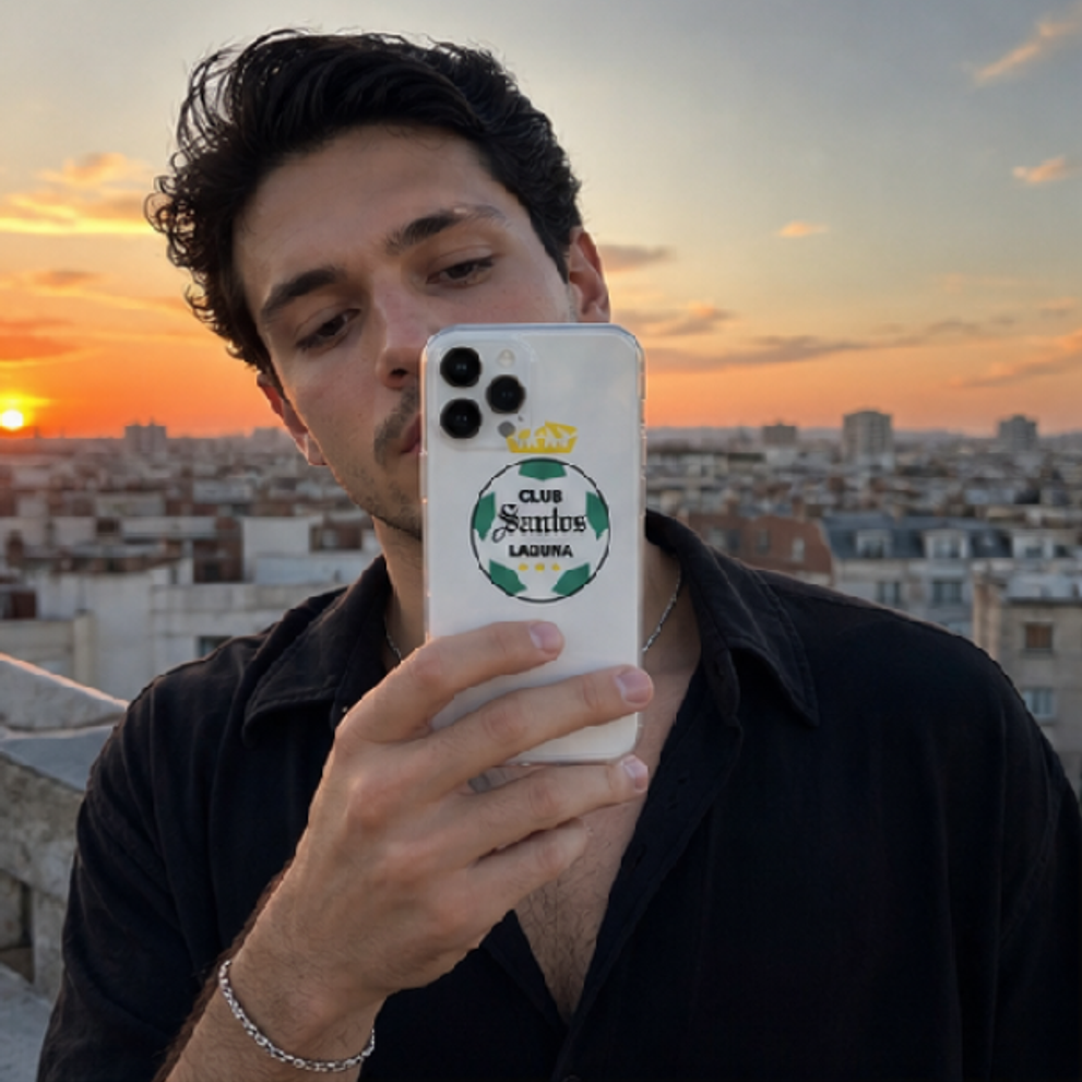 Man holding a phone with a sunset cityscape in the background