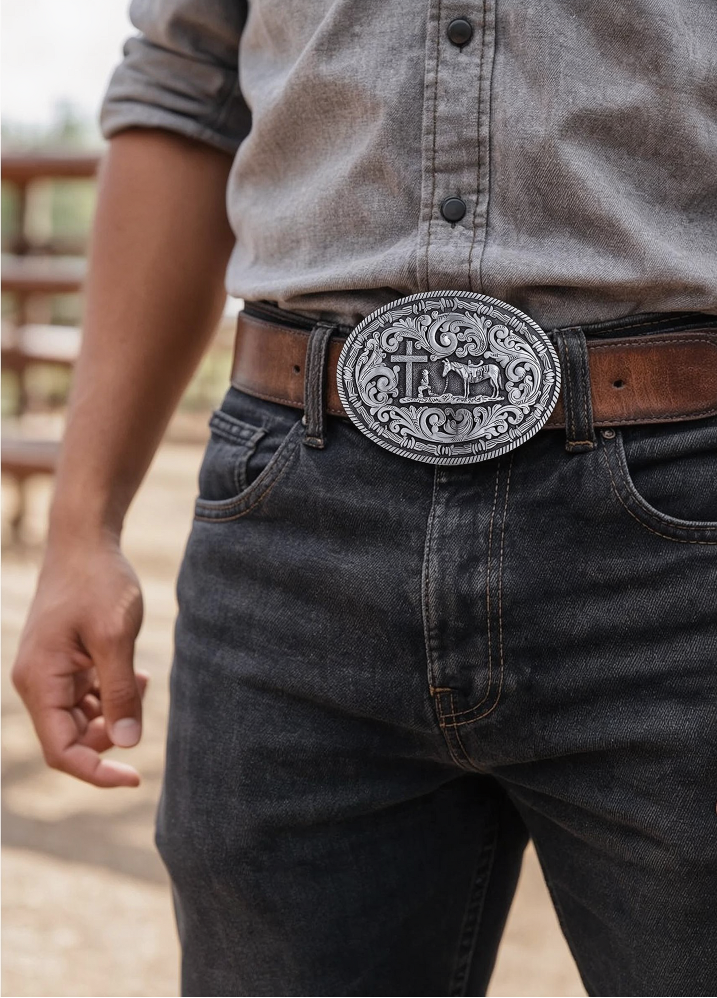 Person wearing a belt with a large decorative buckle outdoors.