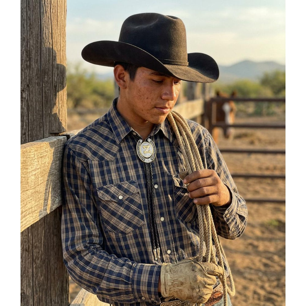 Western bolo tie with silver round slide and gold letter A on dark cord