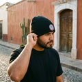 Generales de Durango Cuffed Beanie, Black, One Size | Create the same image, but make the person pose differently and showcase the product in a different way.