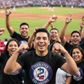 A person wearing a black Tecolotes de los Dos Laredos t-shirt in a 3XL size. The shirt has a baby blue color with a circular logo that includes the Tecolotes Dos Laredos name and branding.
