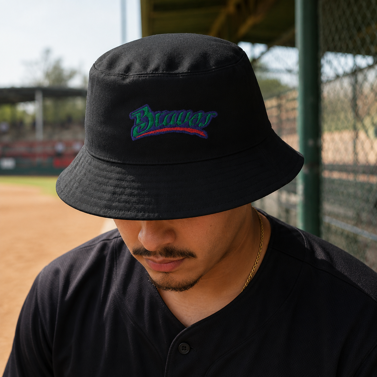 A Mexican model wearing the Bravos de Leon bucket hat in a realistic outdoor lifestyle setting, with the front design clearly visible. The Bravos de Leon bucket hat is shown naturally.
