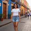 A woman wearing a white crop t-shirt with the text 'Coahuila' printed on the front, paired with blue jeans.