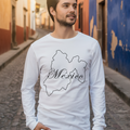 A person wearing a white long sleeve t-shirt with 'Mexico' text in a stylized font inside a outline of the Mexico country shape.