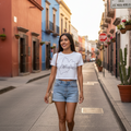 A woman wearing a white crop t-shirt with a map outline of Mexico on it.