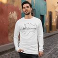A man wearing a white long-sleeve t-shirt with a black outline map of Michigan and the word 'Michoacan' printed on the front, standing on a cobblestone street in front of colorful buildings.