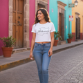 A woman wearing a white crop t-shirt with the text 'Michoacán' printed on the front, paired with blue jeans.
