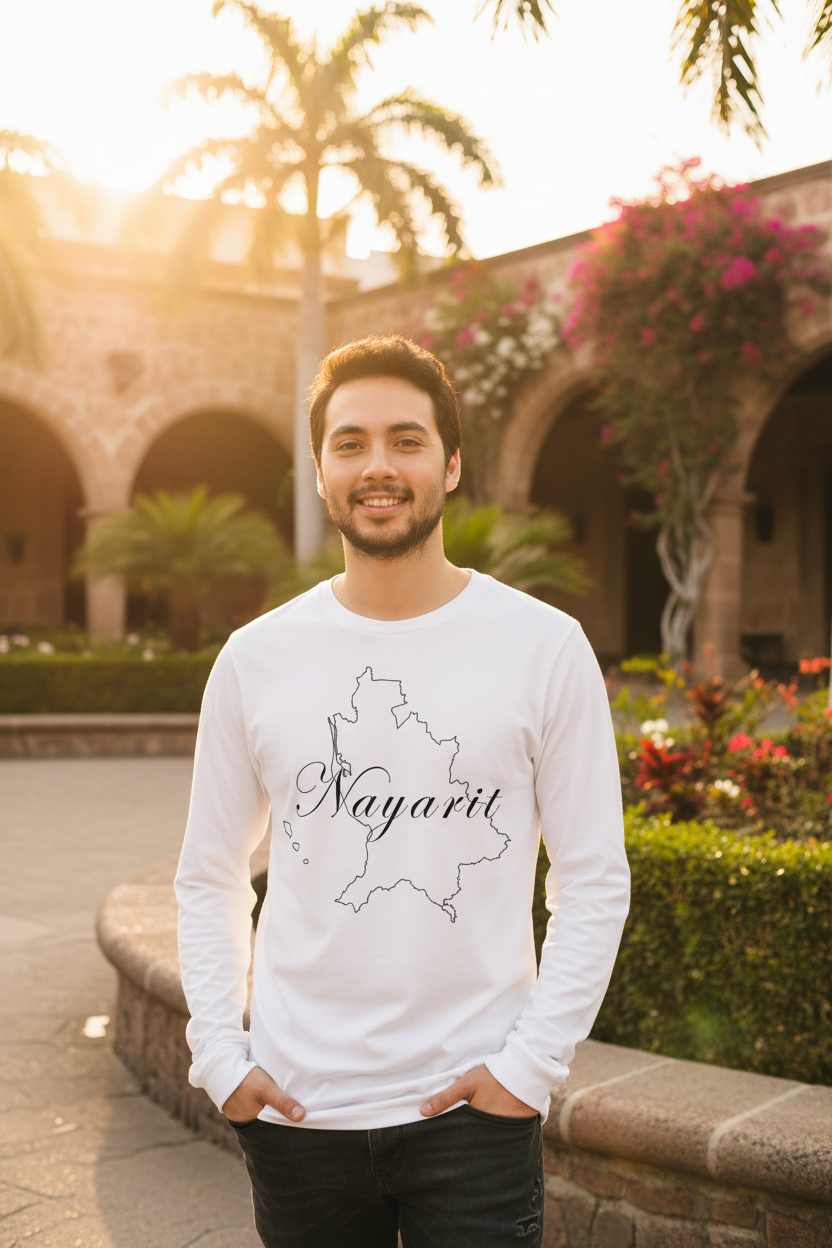 A man wearing a white long-sleeve t-shirt with a black outline map of Nayarit and the word 'Nayarit' written across it, standing outdoors in front of a stone archway building with warm sunset lighting.