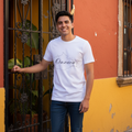 A person wearing a white, short-sleeved unisex T-shirt with the text 'Oaxaca Mexico' printed on the front.