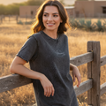 A woman wearing a black denim t-shirt with the text 'Oaxaca' on the front.