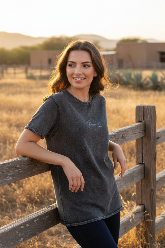 A woman wearing a black denim t-shirt with the text 'Oaxaca' on the front.