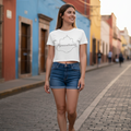 A woman wearing a white cropped T-shirt with 'Aguascalientes' text and a silhouette of a person, paired with blue jeans.