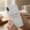 Person holding a silver smartphone with a die-cut bubble-free sticker shaped like the state of San Luis Potosí — featuring white outline and cursive “San Luis Potosí” text, set against a cozy indoor background with warm lighting and a coffee cup, evoking Mexican regional pride and artisanal design.