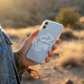A person outdoors in a desert landscape at sunset holds a clear phone case with a white outline of Zacatecas and the word 'Zacatecas' in script.