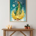 A framed art print of Our Lady of Guadalupe hanging on a white wall above a wooden console table with candles and small potted plants.