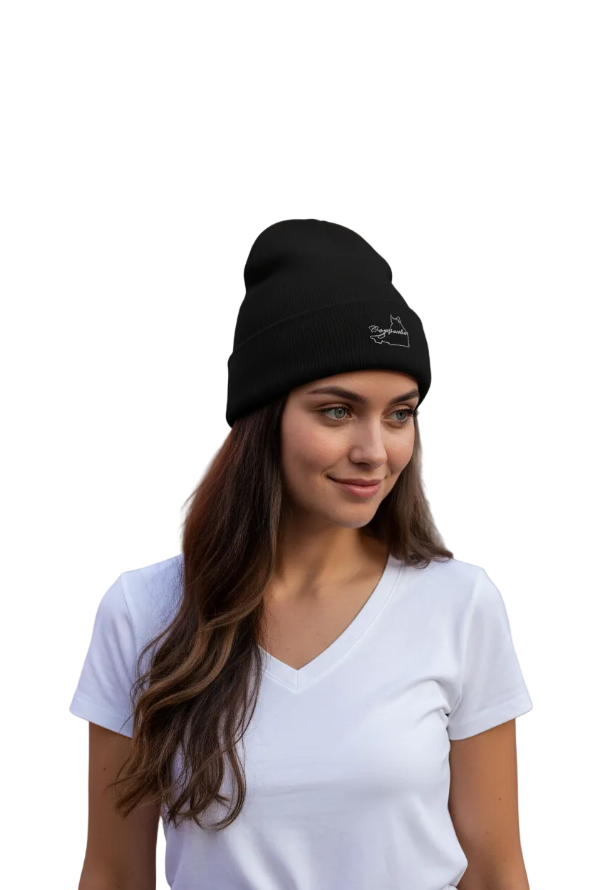 A woman with long brown hair wearing a black knit beanie with a small white Campeche embroidered logo and a white V-neck t-shirt, photographed against a solid white background.