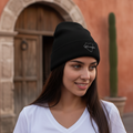 A person wearing a black Durango embroidered beanie hat with a logo on the front.