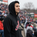 A man wearing a black Aguila de Varacruz hoodie stands in a crowded stadium crowd, looking off-camera. The hoodie features the team's 'A' logo on the chest.
