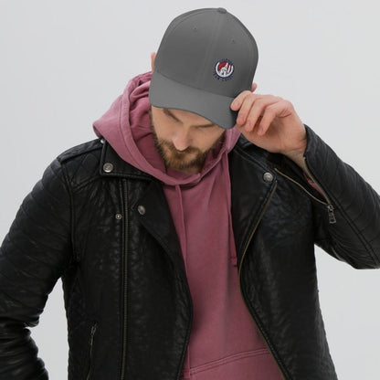A person wearing a gray baseball cap with a Atletico San Luis logo, red hoodie, and black leather jacket.