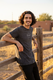 A person wearing a black Guanajuato unisex denim t-shirt with a graphic on the front.