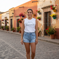 A woman wearing a white muscle tank top with the word 'Guerrero' printed in black text on the front.
