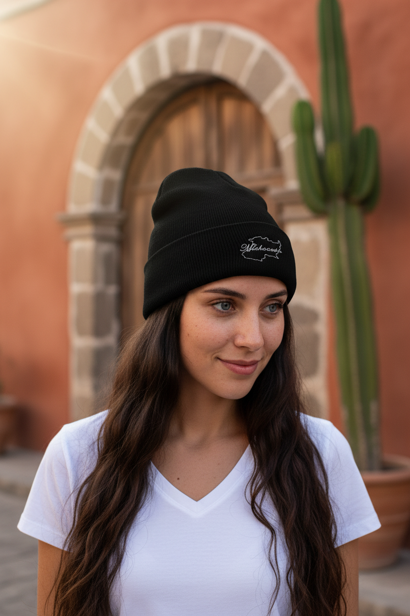 A woman wearing a black beanie hat with an embroidered design on the cuff.