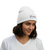 White rib-knit beanie hat with small Oaxaca-style embroidered logo on front