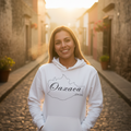 A person wearing a white unisex hoodie with 'Oaxaca' text on it.