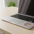 A die cut bubble-free sticker featuring the official coat of arms of Chihuahua, on top of a Mac Book and wooden table.