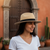 A beige paper straw Panama hat with a black band, an adjustable inner size system, and a detachable chin cord strap.