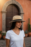 A beige paper straw Panama hat with a black band, an adjustable inner size system, and a detachable chin cord strap.