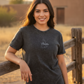A woman wearing a black denim t-shirt with the text 'puebla' written on the front.