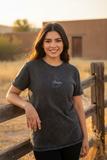 A woman wearing a black denim t-shirt with the text 'puebla' written on the front.