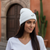 White knit beanie hat with small black embroidered logo, cuffed knit brim