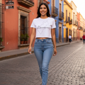A woman wearing a white crop t-shirt with the text 'Queretaro' printed on the front, paired with blue jeans.