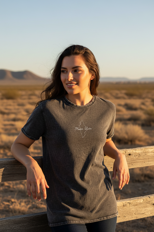 A woman wearing a short-sleeved black denim t-shirt with a round neckline, standing against a white background.