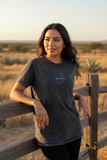 A woman wearing a black denim t-shirt with the text 'quintana roo' on the front.