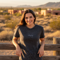 A woman wearing a black short-sleeved t-shirt with the brand name 'Sonora' written on the front.
