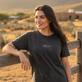A woman wearing a black denim t-shirt with the Tabasco logo on the chest.