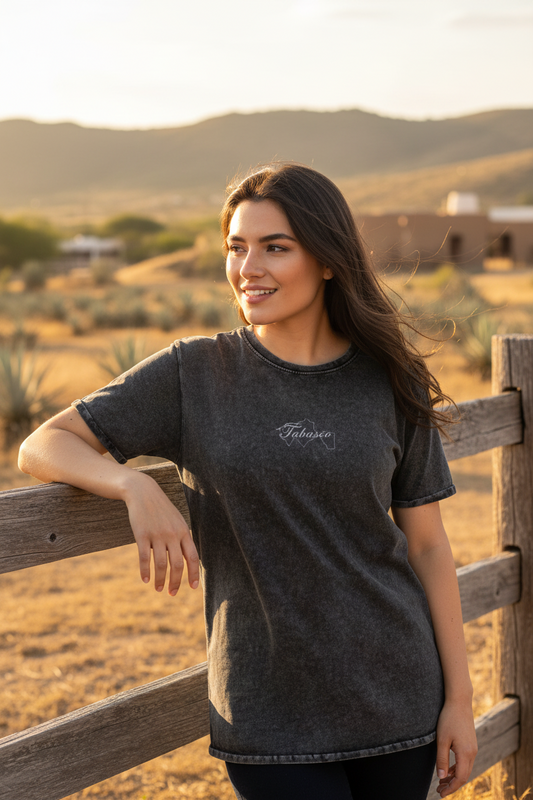 A woman wearing a black denim t-shirt with the Tabasco logo on the chest.