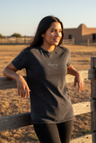 A woman wearing a short-sleeved black denim t-shirt with the text 'Veracruz' on the front.
