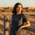 A woman wearing a short-sleeved black denim t-shirt with a round neckline.