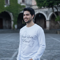 A person wearing a long sleeve white t-shirt with 'San Luis Potosi' text on the front.