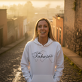 A woman wearing a white hoodie with the text 'Tabasco' on it.
