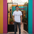 A person wearing a white short-sleeved T-shirt with the word 'Tlaxcala' printed in black script on the front.