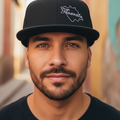 A black snapback hat with a structured high profile, featuring a flat visor and a grey under visor. It has a white embroidered design on the front.