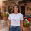 A woman wearing a white crop t-shirt with the text 'Nayarit' printed on the front, paired with blue jeans.