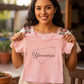 A short-sleeved pink T-shirt with 'Yucatán' written in a stylized font, suitable for a baby.