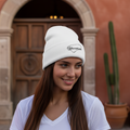A person wearing a white embroidered beanie hat with the text 'Yucatan' on it.